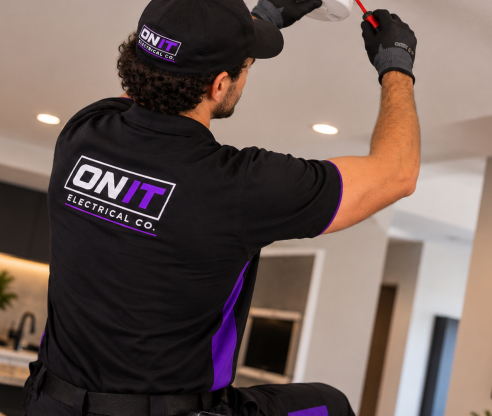 ON IT electrician installing a ceiling smoke alarm